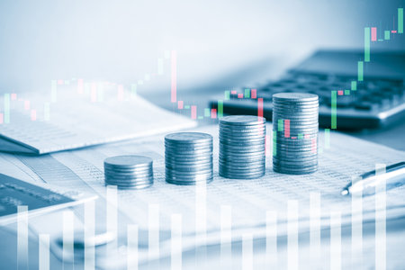 Stack of coins with financial graph and calculator for business and finance conceptの写真素材