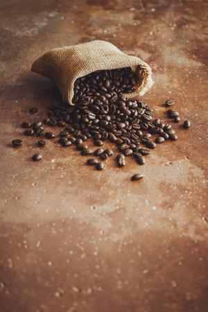 Coffee beans in a burlap bag on a rustic backgroundの写真素材