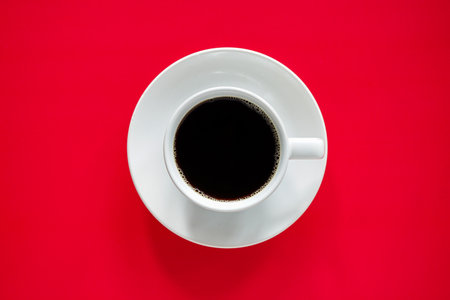 Coffee cup on red background, top view, flat layの写真素材