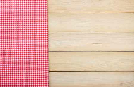 Red tablecloth on wooden background. Top view with copy space.の写真素材
