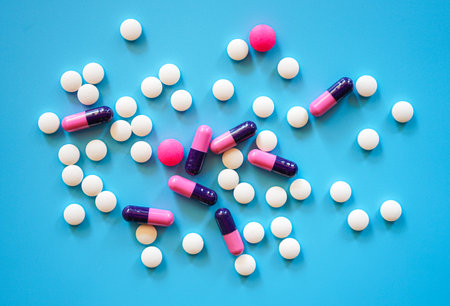 pills and capsules on blue background, top view, copy spaceの写真素材