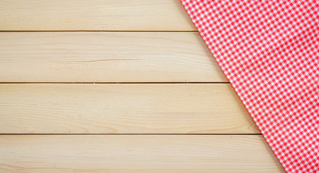 Red checkered tablecloth on wooden background. Top view with copy spaceの写真素材