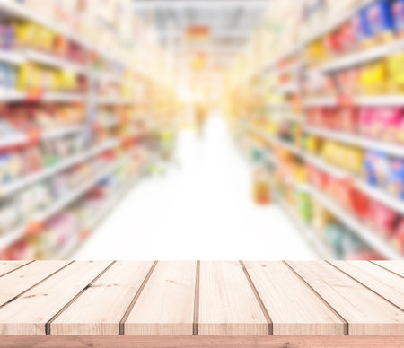 Empty wood table top over blur supermarket background, product display montageの写真素材