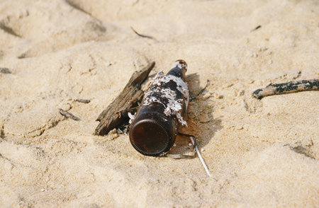 Abandoned bottle on the beach. Concept of environmental pollution.の写真素材