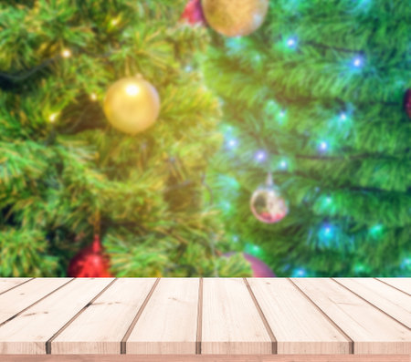 Wood table top on blur christmas tree background - can be used for display or montage your productsの写真素材
