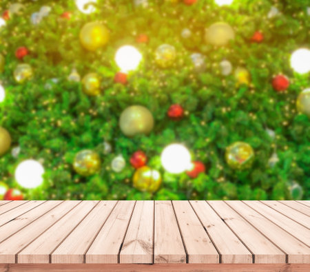 Wood table top on blur christmas tree background - can be used for display or montage your productsの写真素材