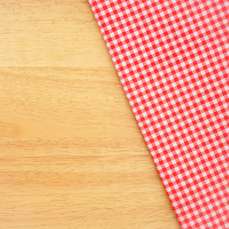 Red checkered tablecloth on wooden background. Top view.の写真素材