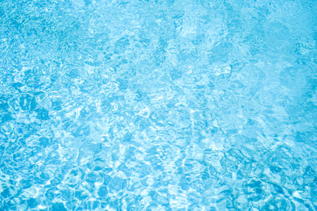 Blue swimming pool water background with sun reflections. Swimming pool textureの写真素材