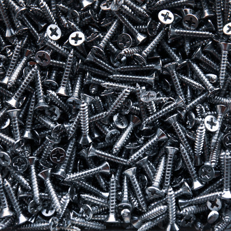 Close up of a pile of screws for construction. Industrial background.の写真素材
