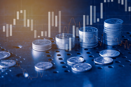 Double exposure of coin stack with stock market graph and candle stick on table.の写真素材