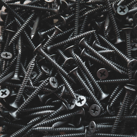 Screws background. Close-up of a pile of black screws.の写真素材
