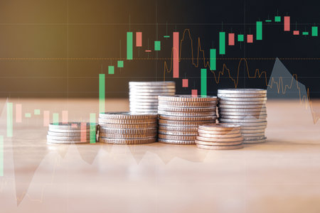 Coins stacked on each other with stock market chart background. Business and finance concept.の写真素材