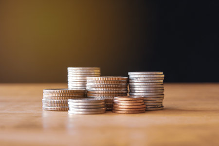 Coins stacked on each other with shallow depth of field and blurred backgroundの写真素材