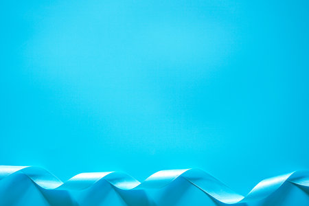 Blue ribbon on blue background with copy space for text or image.の写真素材