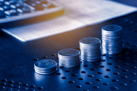 Stack of coins and calculator on table, business and finance concept idea.の写真素材