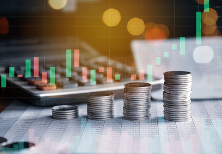 Stacks of coins with stock market or forex trading graph and candlestick chart suitable for financial investment concept.の写真素材