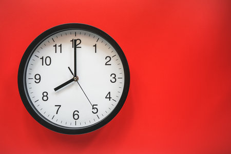 Clock face on red background with copy space for text or image.の写真素材