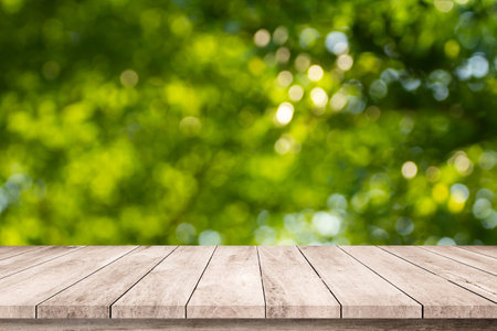 Empty wooden table over blurred green nature background, product display montageの写真素材