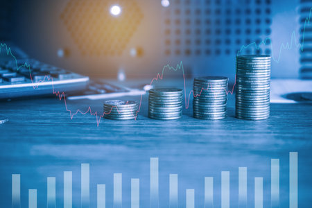 Double exposure of coin stack and graph stock market or forex trading and investment concept.の写真素材