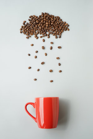 Coffee beans flying out of a red cup on white backgroundの写真素材