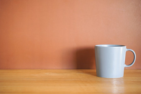 Coffee cup on wood table and brown wall background, stock photoの写真素材