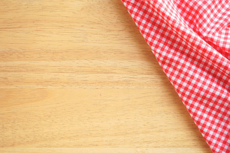 Red checkered tablecloth on wooden background with copy space.の写真素材