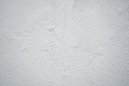 White concrete wall with cracks and scratches. Abstract background for design.の写真素材