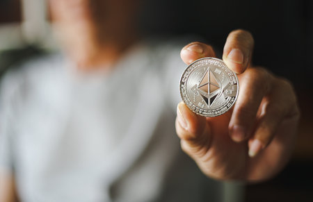 Man holding silver ethereum cryptocurrency coin. Cryptocurrency concept.の写真素材