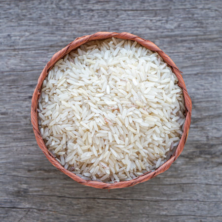 Rice in a basket on wooden background, top view, close upの写真素材