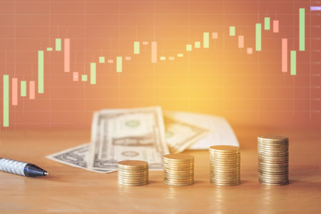 Investment concept, Coins graph stock market on wooden table and candlestick chart background.の写真素材