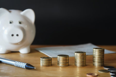 Piggy bank and coins on wooden table with copy space.の写真素材