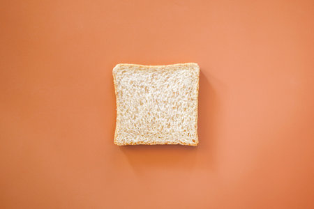 Slice of white bread on orange background. Top view, copy spaceの写真素材