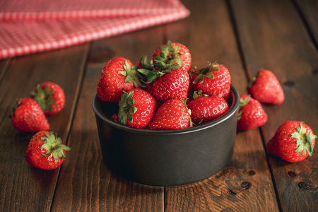 Fresh strawberries in a bowl on a wooden background. Healthy food.の写真素材