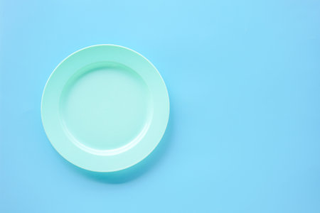 Empty plate on blue background. Top view. Copy space for your text.の写真素材