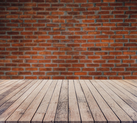 Wood table top on blur brick wall background - can be used for display or montage your productsの写真素材