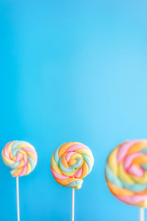 Colorful lollipops on blue background. Sweet food.の写真素材