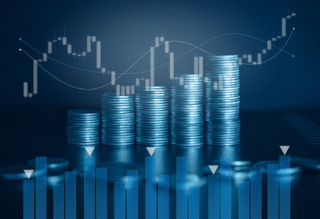 Double exposure of coin stack with stock market graph on blue background.の写真素材