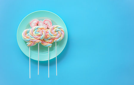 Colorful marshmallows on a blue plate on a blue backgroundの写真素材