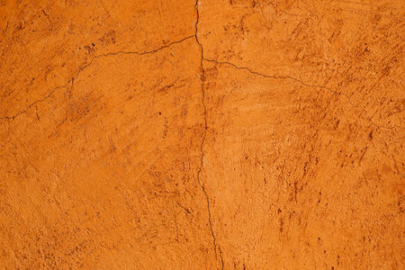 Cracked orange cement wall texture background for interior or exterior design.の写真素材