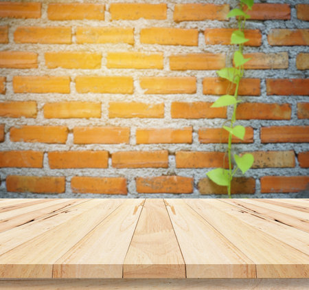 Wood table top on blur brick wall background - can be used for display or montage your productsの写真素材