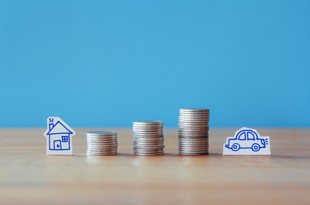 House model and stack of coins with blue background, real estate conceptの写真素材