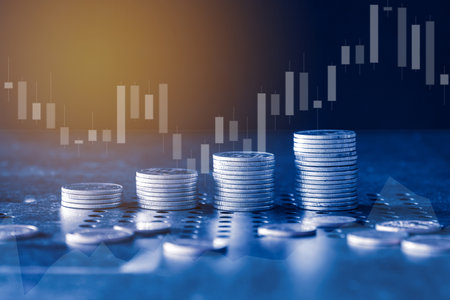 Stack of coins for finance and banking concept with stock market graph background.の写真素材
