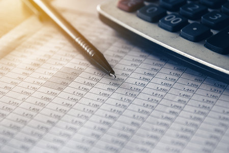 Accounting concept. Calculator and pen on the table with financial data.の写真素材