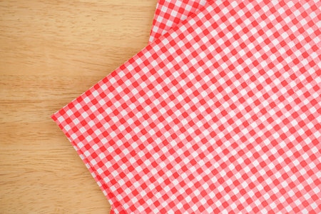 Red checkered tablecloth on wooden background. Top view.の写真素材