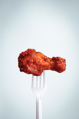Fried chicken on a fork on a white background. Toned.の写真素材