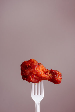Fried chicken on a fork, isolated on a gray background.の写真素材
