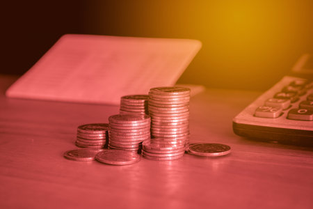 Coins on the table with the calculator and book for business concept.の写真素材
