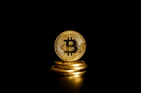 Golden Bitcoin on black background. Cryptocurrency and finance concept.の写真素材