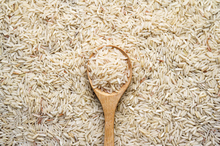 Rice in wooden spoon on white rice background. Top view.の写真素材