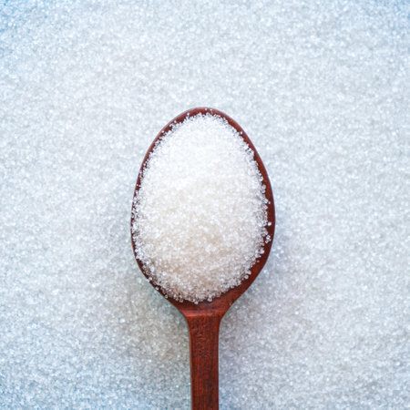 sugar in a wooden spoon on a background of white sugar.の写真素材